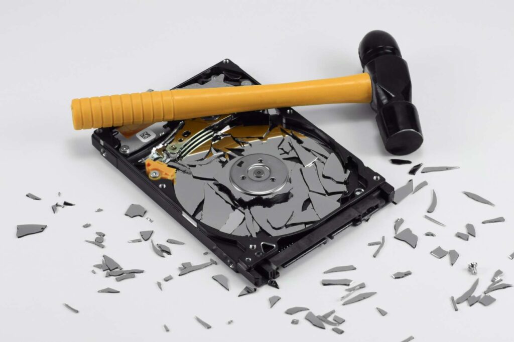 Hammer breaking a hard drive for secure data destruction in Georgia and Florida